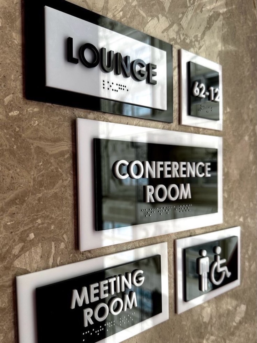 Black and white acrylic room signs with braille: Lounge, Conference Room, Meeting Room
